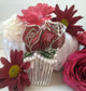 Photo du Peigne en argent représentant deux roses rouges émaillées en plique à jour avec 11 perles de nacre. Peigne entouré de fleurs rouges, roses, et blanches.